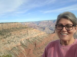 Shael McDonald smiles with a vast landscape in the background.